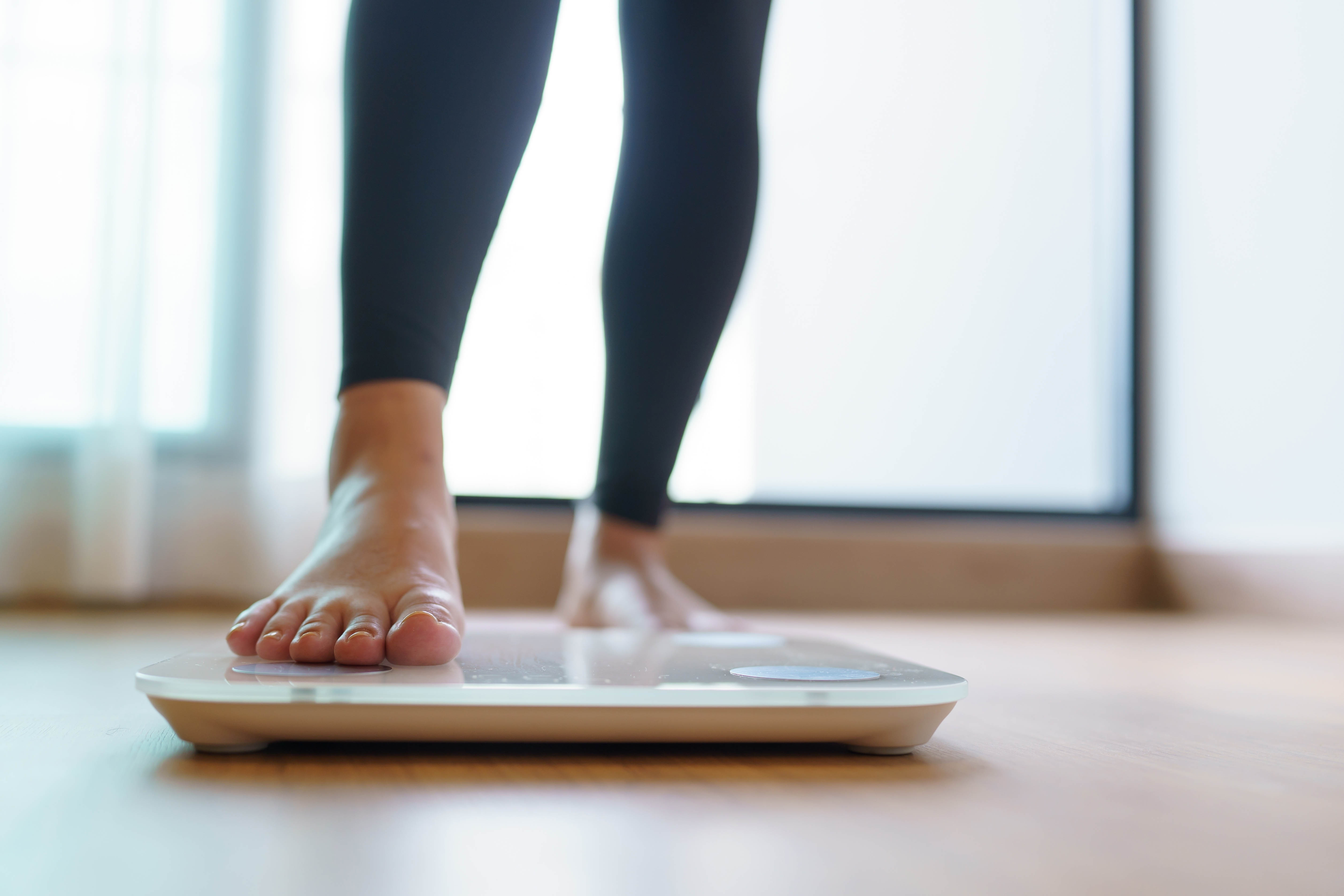 Close-up of a woman's foot stepping onto a scale